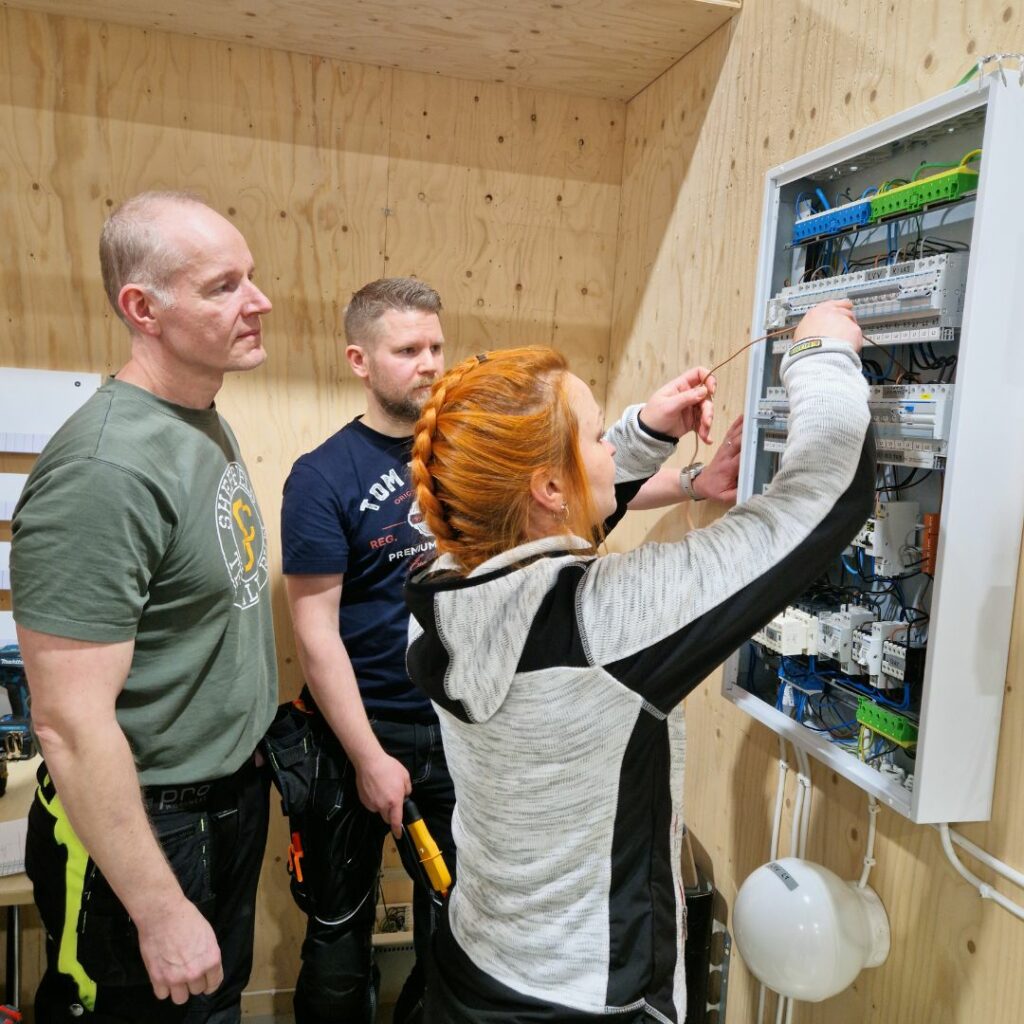 Sähköalan opiskelijat tekemässä harjoituksia sähköalan työsalissa.